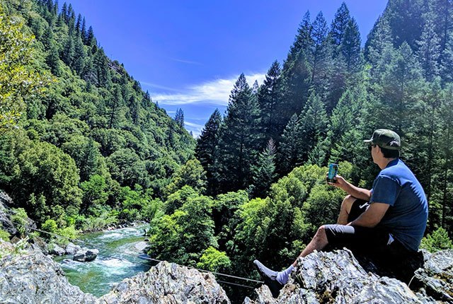 Man looking out at a river and mountains | Quality Automotive Servicing